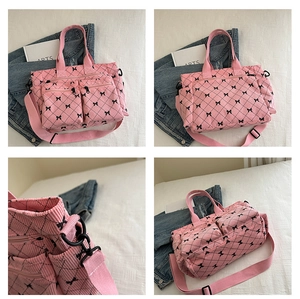Detail of pink corduroy tote bag featuring black bow patterns and functional side pockets