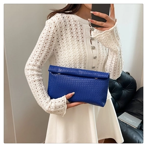 Detail of royal blue woven leather clutch with premium checkered texture for women
