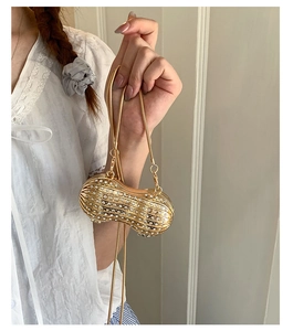 Vista dettagliata di una mini borsa da sera a forma di arachide con strass dorati e bianchi
