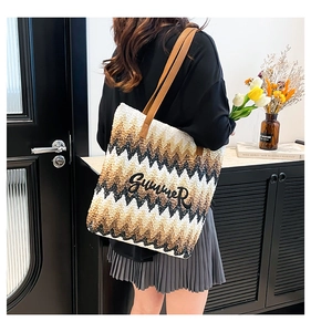 Close-up of woven tote bag with SUMMER embroidery and premium brown leather straps