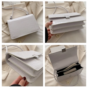 Detail view of white crocodile pattern shoulder bag showing three interior compartments