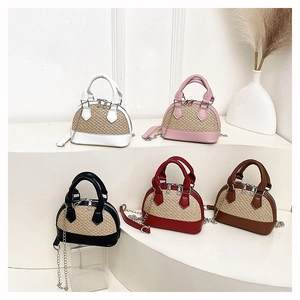 Detail of colorful straw woven shell bags with metallic chains and leather handles