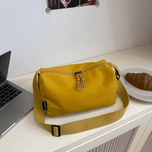 Minimalist ginger nylon tote bag with wide strap and laptop on a clean white desk