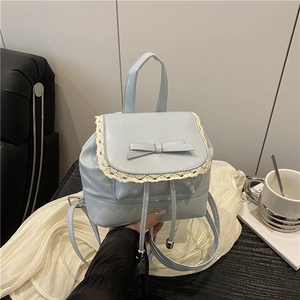 Mini sac à dos bleu clair style ballet avec nœud et dentelle sur table en bois noir