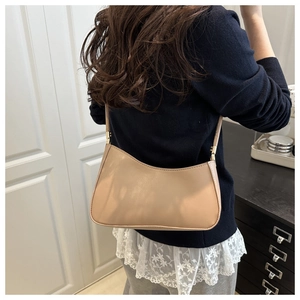 Beige faux leather baguette shoulder bag shown on model for size and style reference