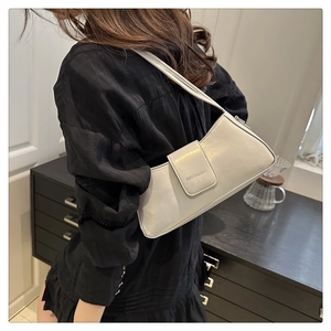 White leather baguette shoulder bag shown on model for stylish commute lifestyle
