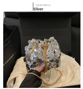 Close-up of silver sequin bucket bag with gold chain strap and pearl accents