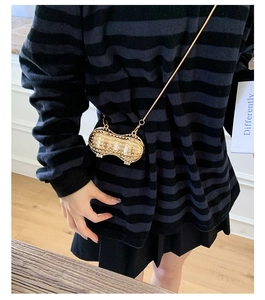 Peanut-shaped mini evening bag in gold metal with pearls on a crossbody model