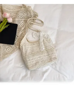Macro view of floral lace pattern and ribbon bow detail on the white tote bag