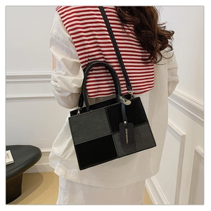Detail of contrast color crossbody bag showing stylish tag and shoulder strap fit