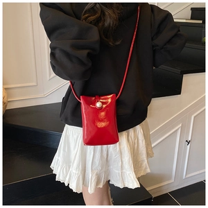 Back view of a mini red patent leather crossbody bag with a large pearl clasp detail