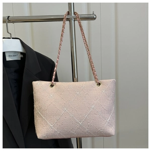 Detail of light pink plaid tote bag featuring floral embroidery and gold chain strap