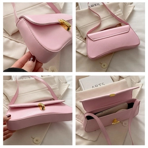 Detail view of pink leather underarm bag with gold metal buckle and internal phone space