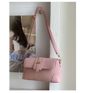 Detail of pink baguette bag featuring woven texture mix and elegant gold hardware