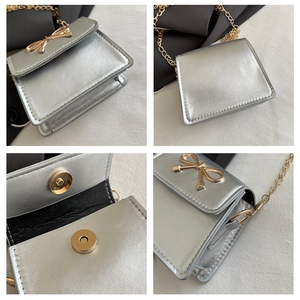 Detailed views of silver saddle bag with golden bow clasp and metal chain strap