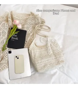 Detailed close-up of cream lace crochet shoulder bag with delicate white ribbon bow