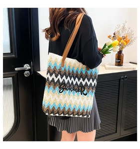 Detail of colorful zigzag woven tote bag with SUMMER lettering and leather straps