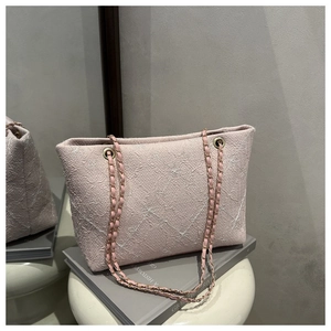 Close-up of pink jacquard tote bag featuring floral patterns and gold chain strap