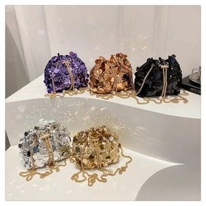 Detail of colorful sequin bucket bags with gold chains and pearl accents in a group