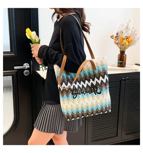 Detail of bohemian woven straw tote featuring chevron pattern and Summer embroidery