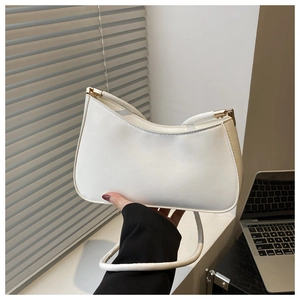 Detail of a minimalist white half-moon shoulder bag with sleek leather and gold hardware