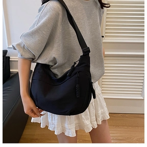 Détail du sac croissant en nylon noir avec bandoulière large et tirette de zip tissée