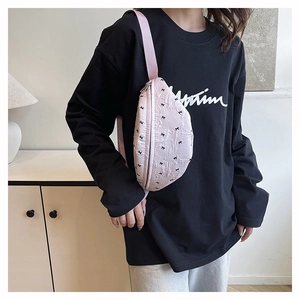 Close-up of pink crossbody chest bag with cute black bow patterns on model