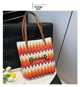 Detail of V-shaped woven straw tote with Summer embroidery and leather handles