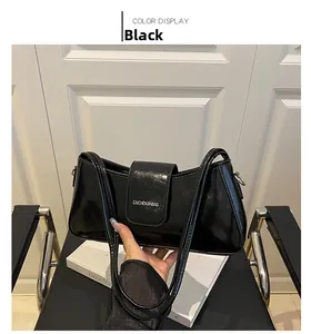 Detail of glossy black handbag showing rectangular flap and brand logo on the front