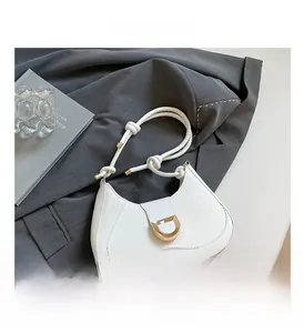 Detail of white half-moon leather shoulder bag with gold D-buckle and knotted strap