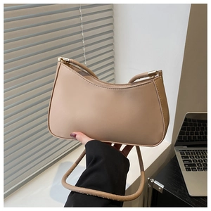Detail showing high-quality beige underarm bag with gold metal zipper and matte finish