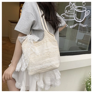 Detailed close-up of white lace star pattern on a tote bag with an elegant bow accent