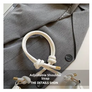 Detail of adjustable knotted leather shoulder strap with gold circular metal accents
