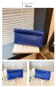 Detail of woven royal blue envelope clutch with textured checkered pattern and flap closure