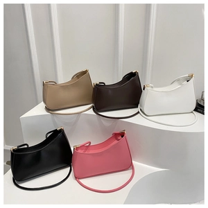 Minimalist crescent shoulder bags in multiple colors displayed on geometric pedestals
