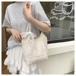 Détail de broderie en dentelle florale et nœud en résille sur sac cabas crème style urbain