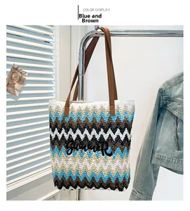 Detail of blue and brown woven tote bag featuring Summer embroidery and leather handles
