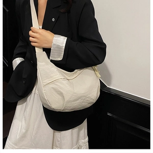 Vue détaillée de la capacité du sac croissant ivoire et sa texture sur le modèle