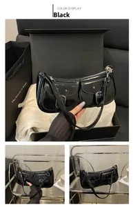 Detailed view of black patent leather baguette bag with dual pockets and silver buckles