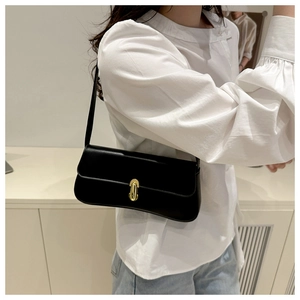 Detail of black leather underarm bag with elegant gold metal twist lock closure