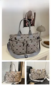 Macro detail of grey quilted corduroy tote with black bow print and zip pockets