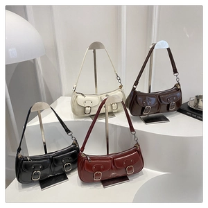 Detailed view of vintage glossy leather underarm bags in four elegant colors with metal buckles
