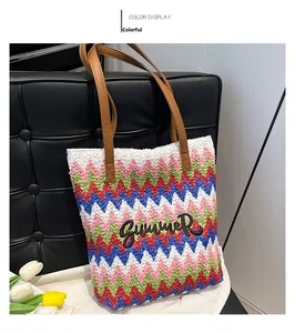 Detail of colorful woven straw bag with Summer embroidery and brown leather handles