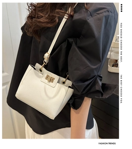 Mannequin portant un sac à main blanc en cuir grainé avec fermoir rotatif doré