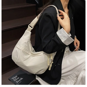 Sac fourre-tout minimaliste en nylon blanc crème avec bandoulière sur escalier