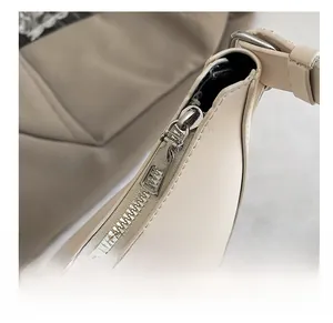 Detailed macro view of the smooth silver zipper and fine cream leather texture