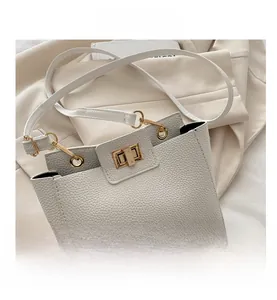 Détail du sac bandoulière blanc grainé avec fermoir rotatif en métal doré chic