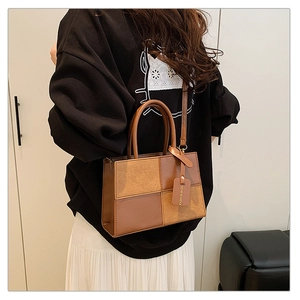 Detailed view of vintage patchwork shoulder bag with dual handles and suede texture