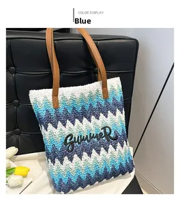 Detail of blue gradient woven tote bag with Summer embroidery and brown leather handles