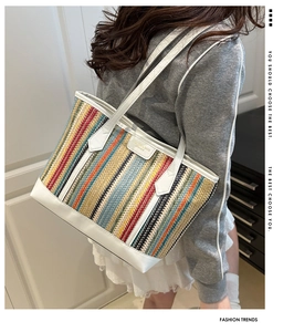 Détail de rayures colorées tissées et de poignées en cuir blanc sur un grand sac cabas